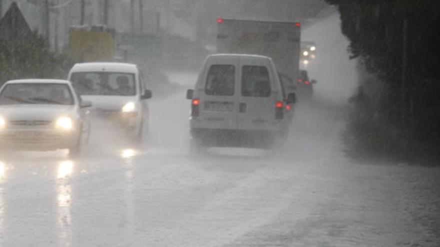 Coches circulan a duras penas por una carretera de Murcia mientras la lluvia descarga a gusto.