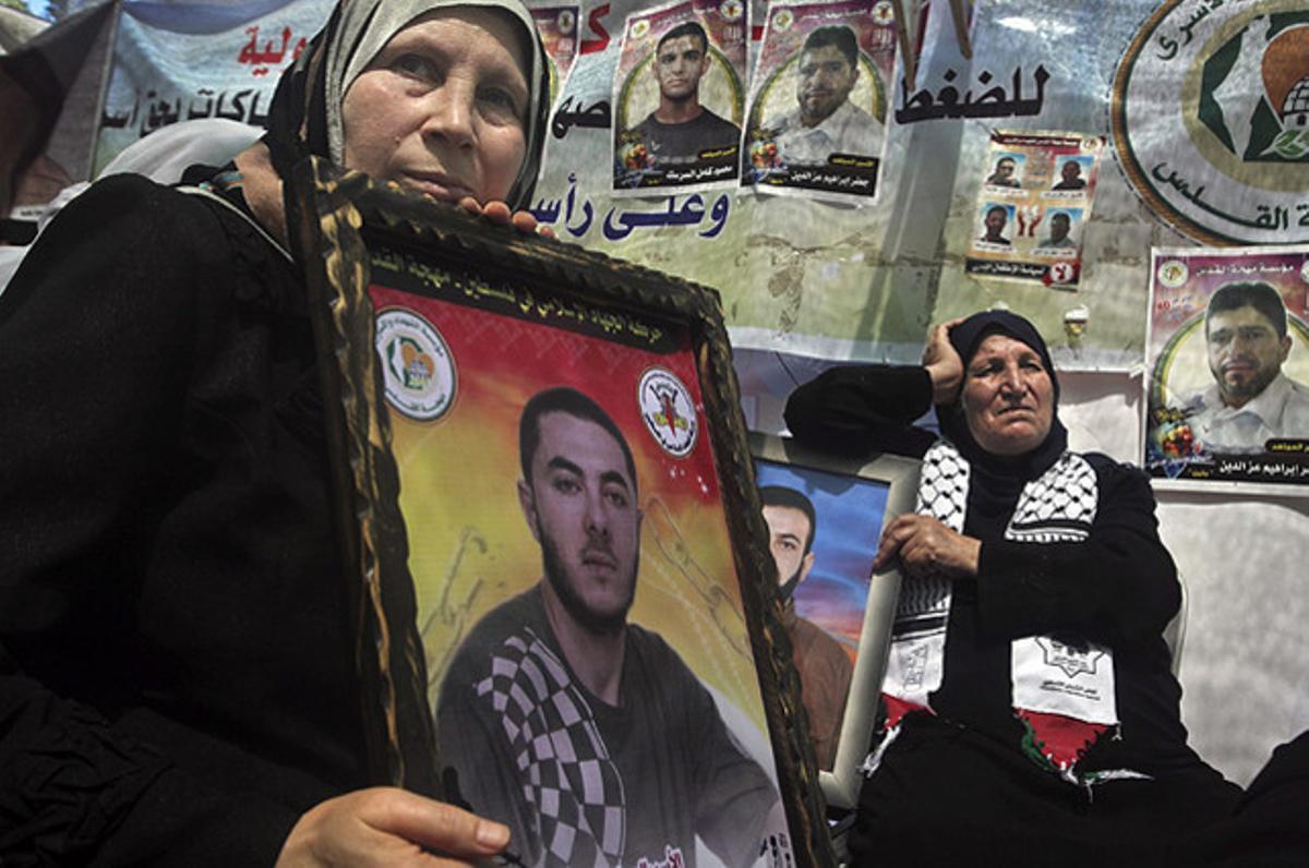 Dues dones palestines sostenen retrats dels seus fills presos, durant una concentració a Gaza en suport dels reclusos palestins a Israel que estan en vaga de fam.