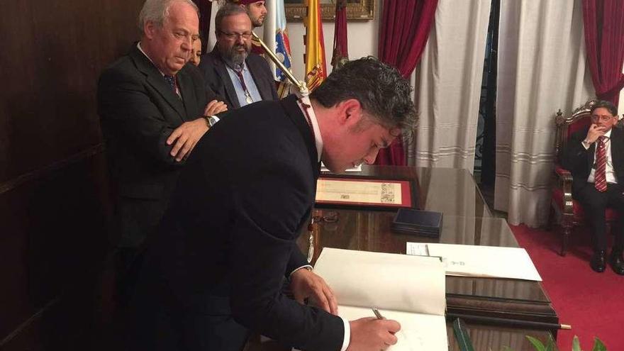 Jorge Vázquez estampa su rúbrica en el &#039;Libro de firmas&#039; del Concello, ante la mirada del alcalde, Ramón García.