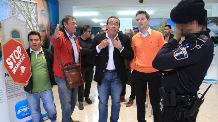 Torró y Soler, conversan con Joan Cogollos, ante un Policía Local, en la sede del PP de Gandía.