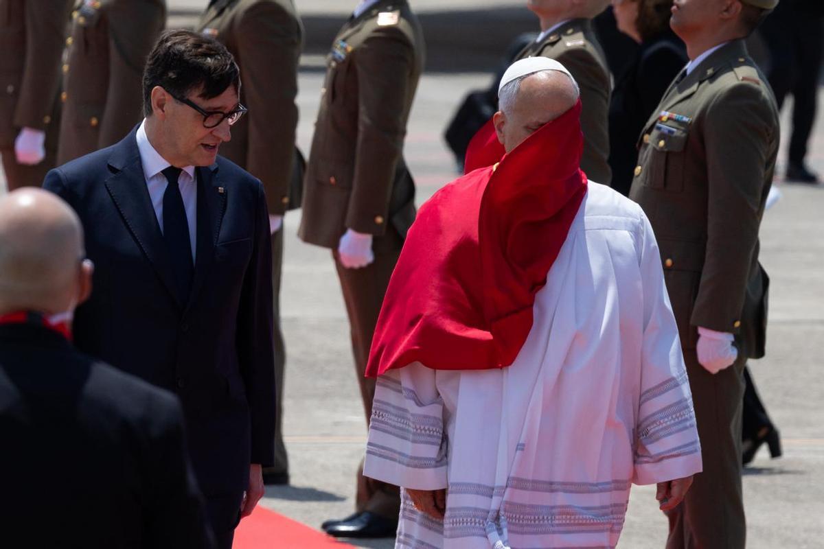 El papa León XIV, a su llegada al aeropuerto de Barcelona. A su lado, Salvador Illa, presidente de la Generalitat, que le ha recibido a pie de avión.