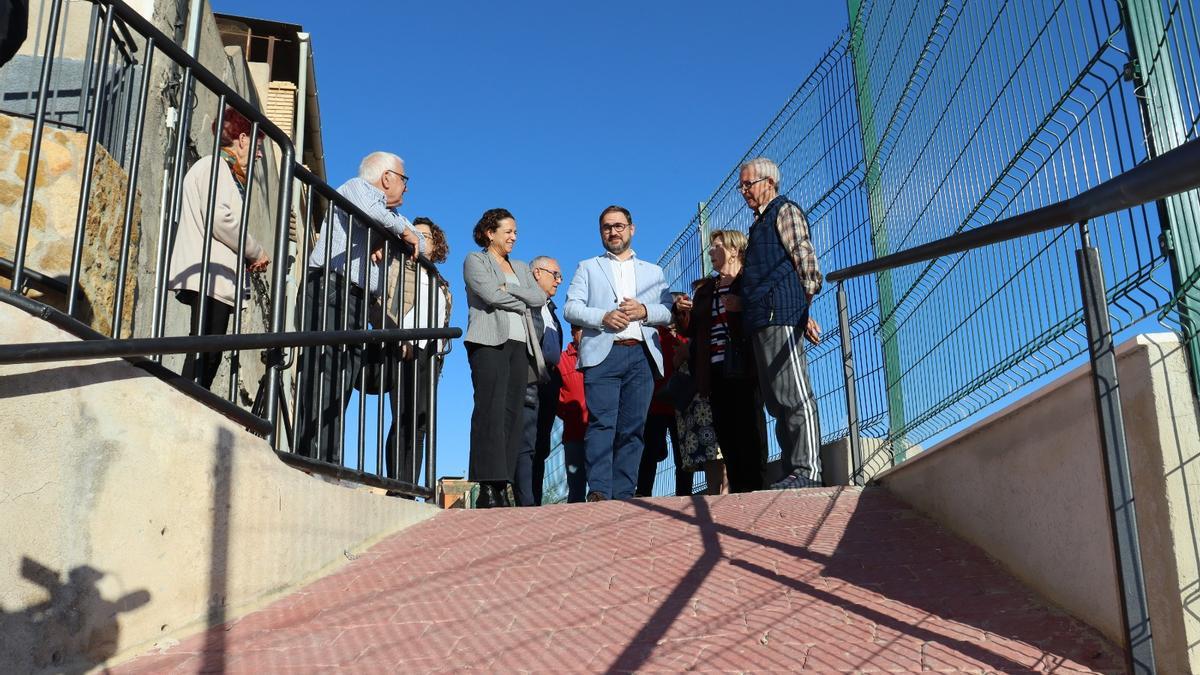 Isabel Casalduero y Diego José Mateos junto a vecinos de la zona en lo más alto de la rampa adoquinada que se ha construido.