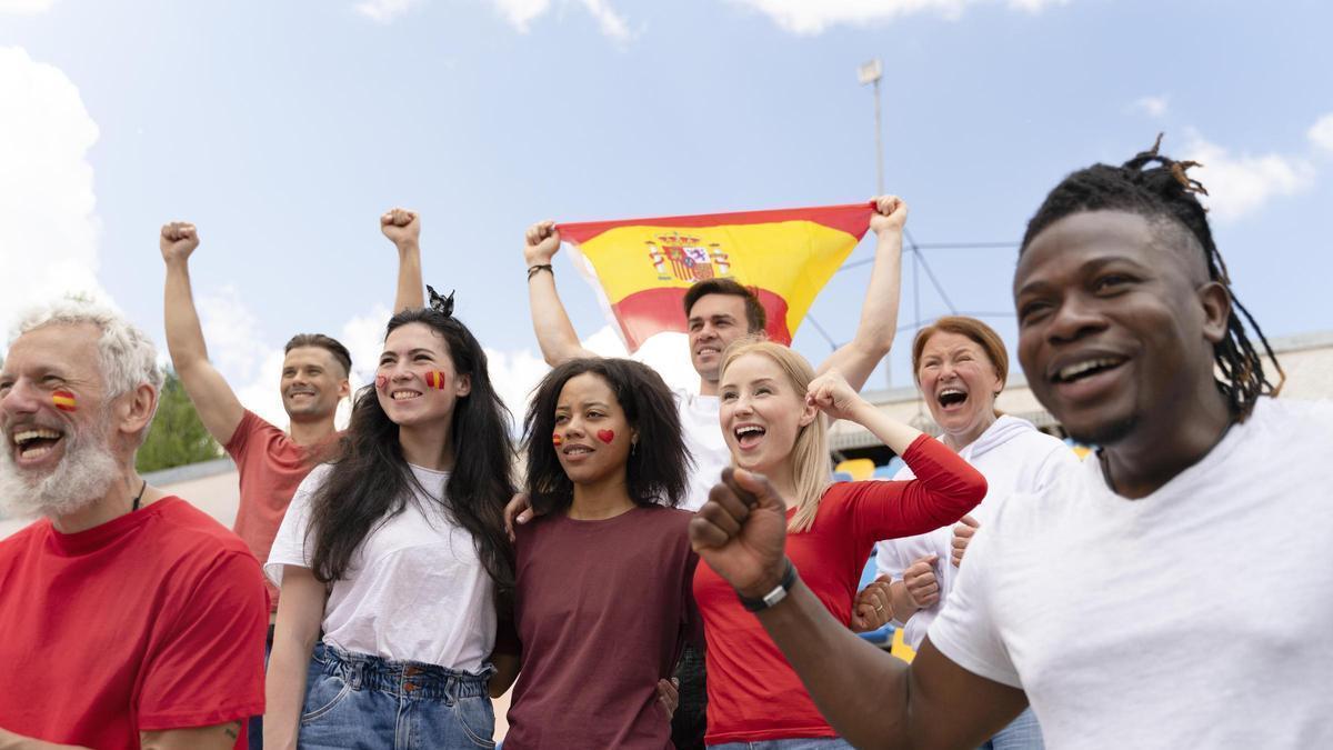 Varias personas asistiendo a un partido de fútbol desde la grada