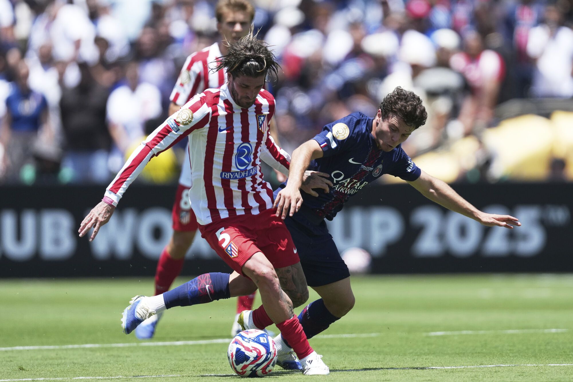 Paris Saint-Germain's Joao Neves, right, and Atletico Madrid's Rodrigo De Paul battle for the ball during the Club World Cup group B soccer match between PSG and Atletico Madrid in Pasadena, Calif., Sunday, June 15, 2025. (AP Photo/Jae Hong)