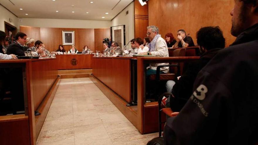 Participantes en el Pleno municipal, con un bombero sentado en el lugar reservado para el público.