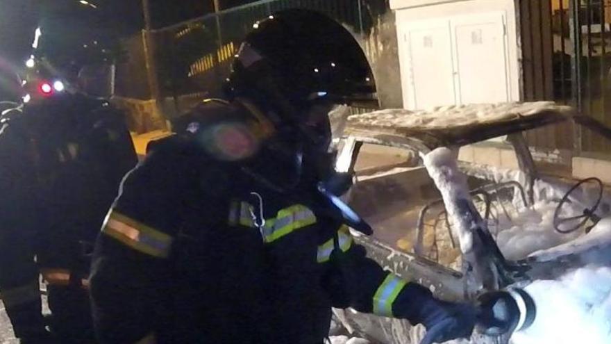 Los bomberos, durante la extinción del incendio originado en un coche