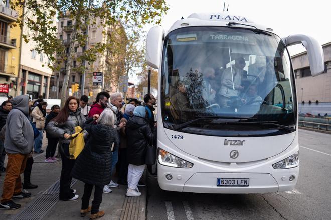 Usuarios hacen cola en la plaza de Espanya para tomar autobuses en dirección a Tarragona