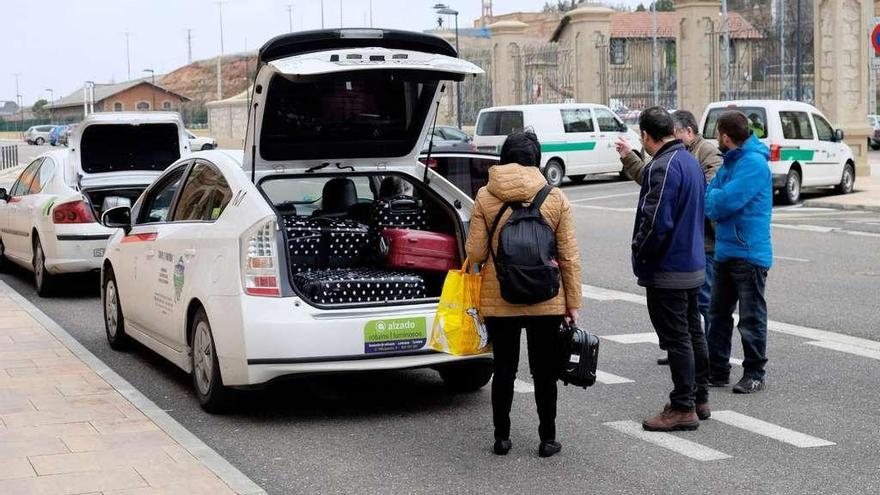 Pasajeros afectados por los retrasos toman un taxi en la estación.