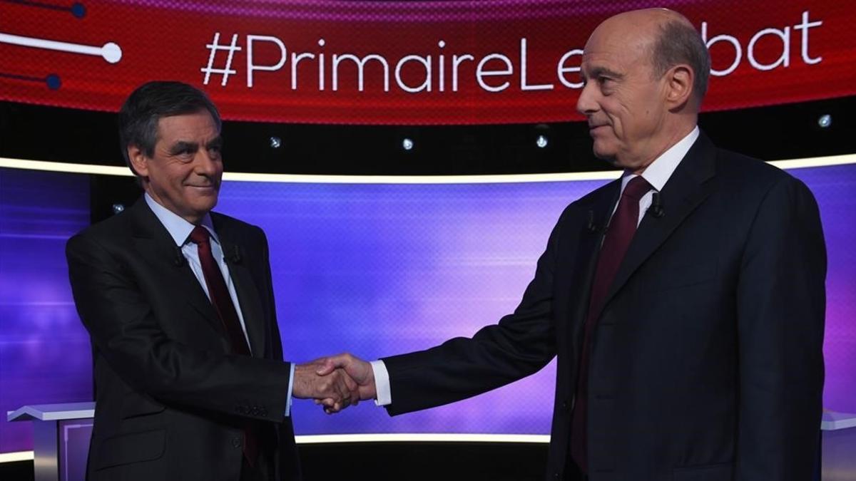 Fillon (izquierda) y Juppé se dan la mano antes del debate televisado, este jueves, en París.