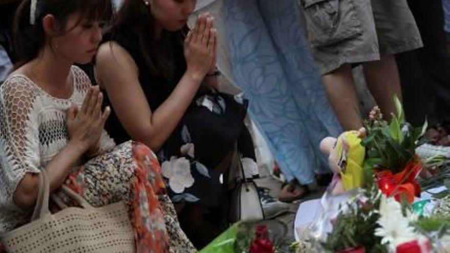 Dues dones resen al memorial de les Rambles per honrar la memòria de les víctimes.