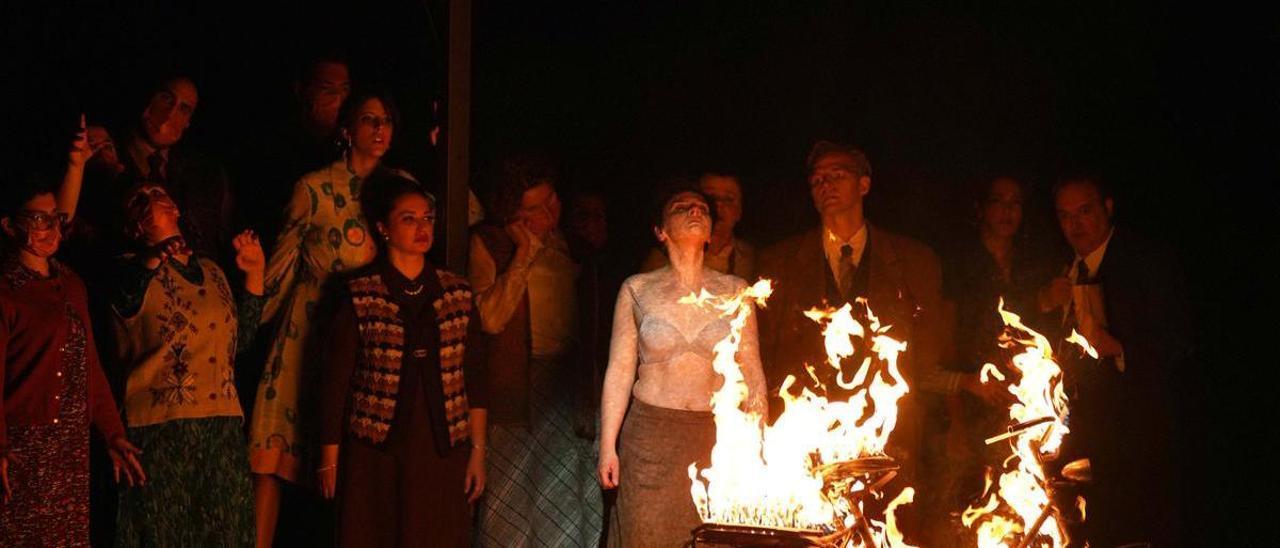 Coro Titular del Teatro Real (todos con mascarillas) y, de izquierda a derecha Anna Gomà (Novicia II), Nino Surguladze (Posadera), Ausrine Stundyte (Renata), Agnieszka Rehlis (La Madre Superiora / Vidente), Dmitry Golovnin (Agrippa von Nettesheim / Mefistófeles), Estíbaliz Martyn (Novicia I) y Josep Fadó (Jackob Glock / Doctor).