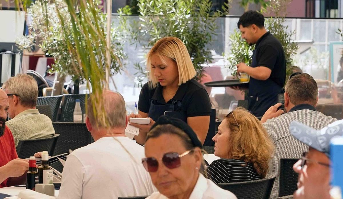 Camareros atendiendo a los clientes en la terraza de un restaurante en Málaga, donde el paro ha vuelto a bajar en marzo de 2026.