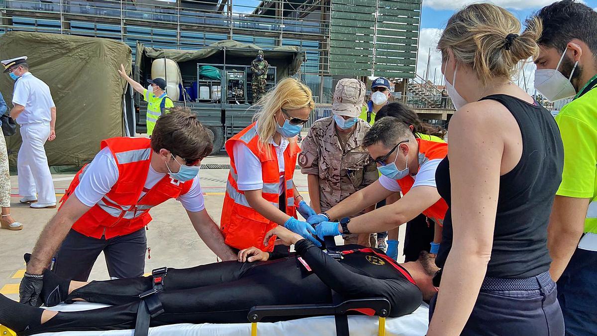 Cruz Roja, Emergencias y los sanitarios del Ejército asisten al buceador herido tras la descontaminación. | IVÁN URQUÍZAR