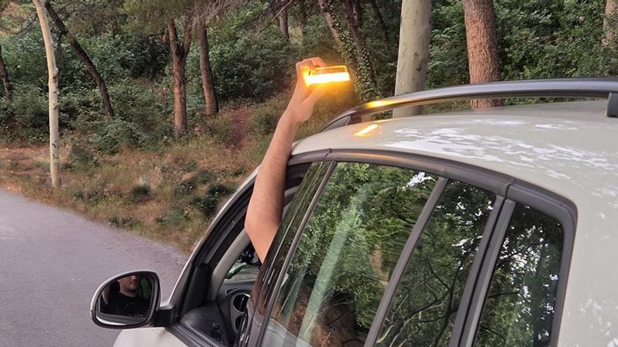 Conductor colocando la baliza V16 sobre el techo de su vehículo