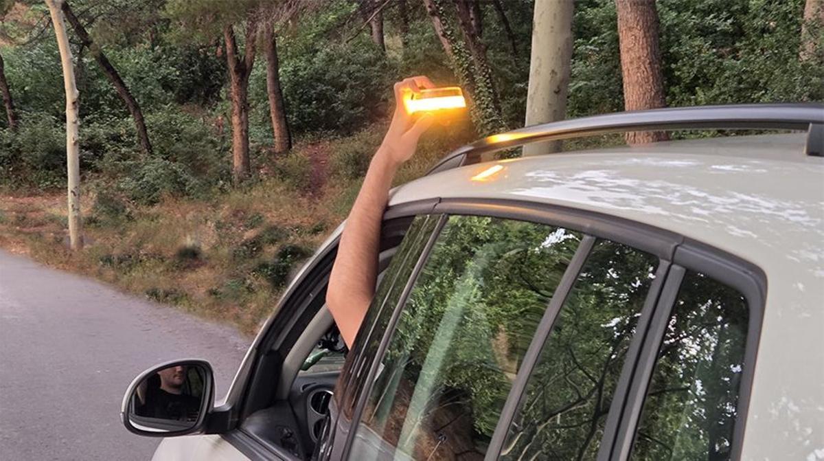 Conductor colocando la baliza V16 sobre el techo de su vehículo