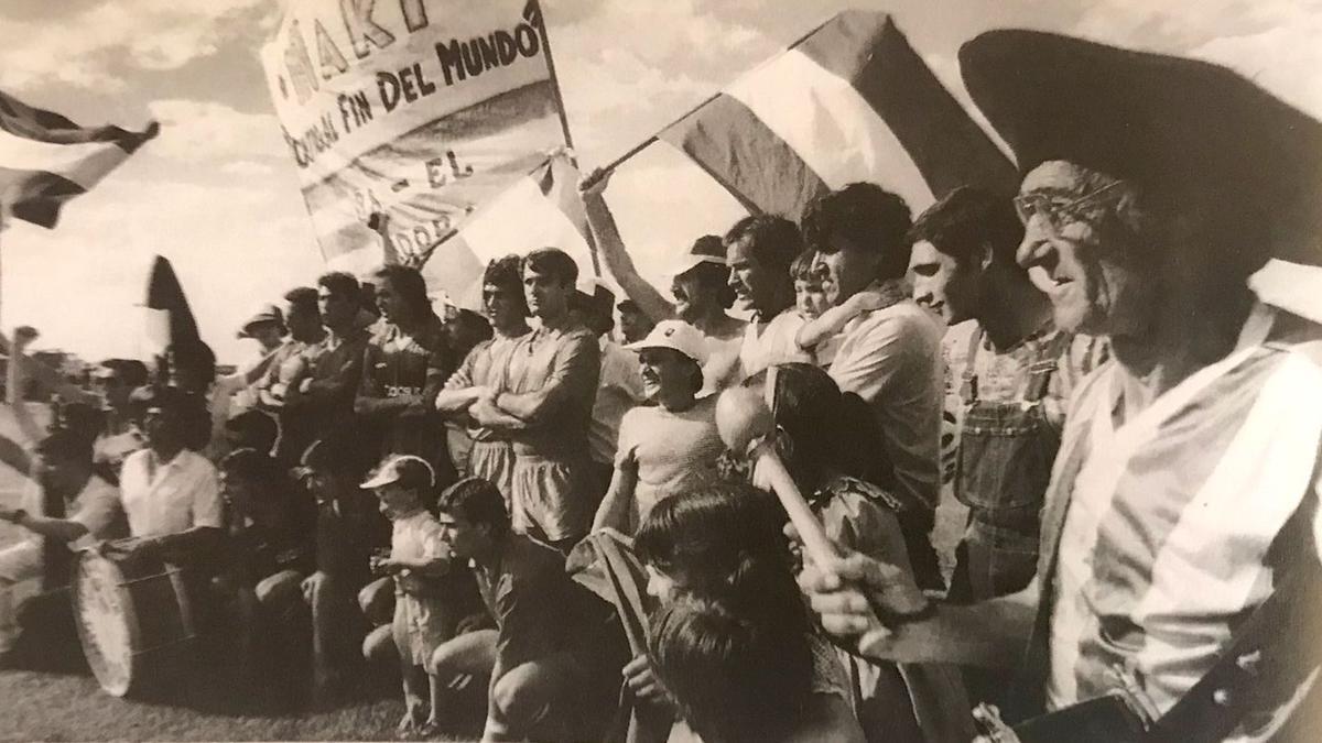 Jugadores y aficionados del Córdoba CF sobre el campo del Valdepeñas en 1985, en los instantes previos al partido en el que se logró el ascenso a Segunda B.