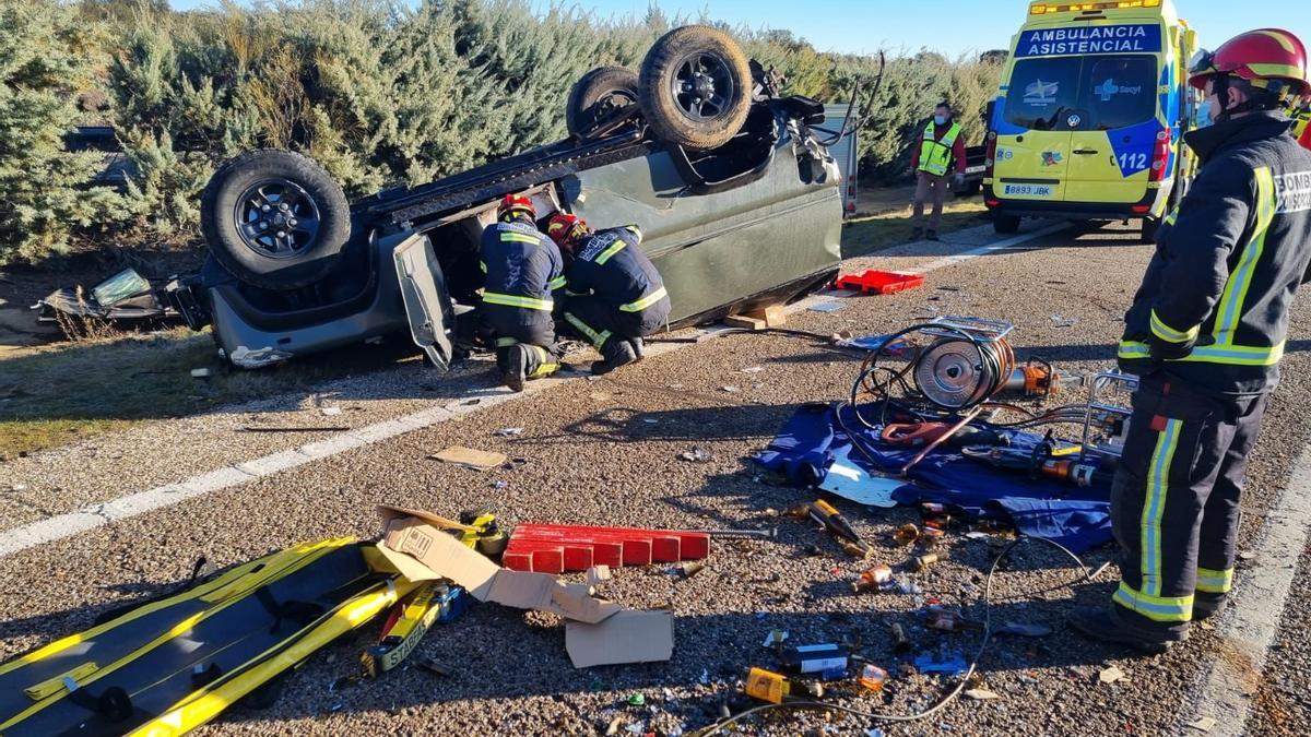 Dos bomberos excarcelan al copiloto del vehículo, que había quedado atrapado.