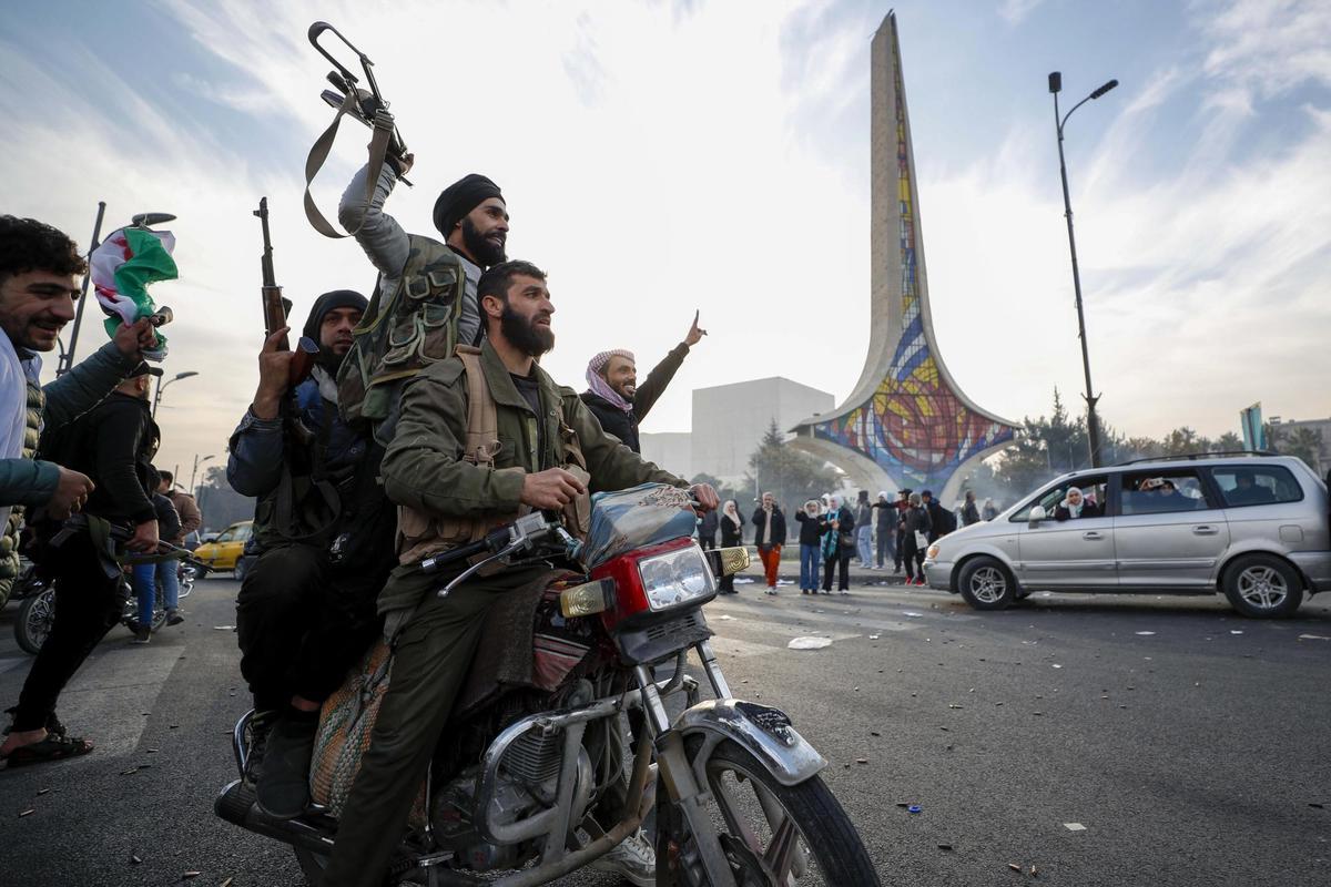 Los rebeldes sirios celebran la caída del gobierno sirio en Damasco, Siria, el domingo.