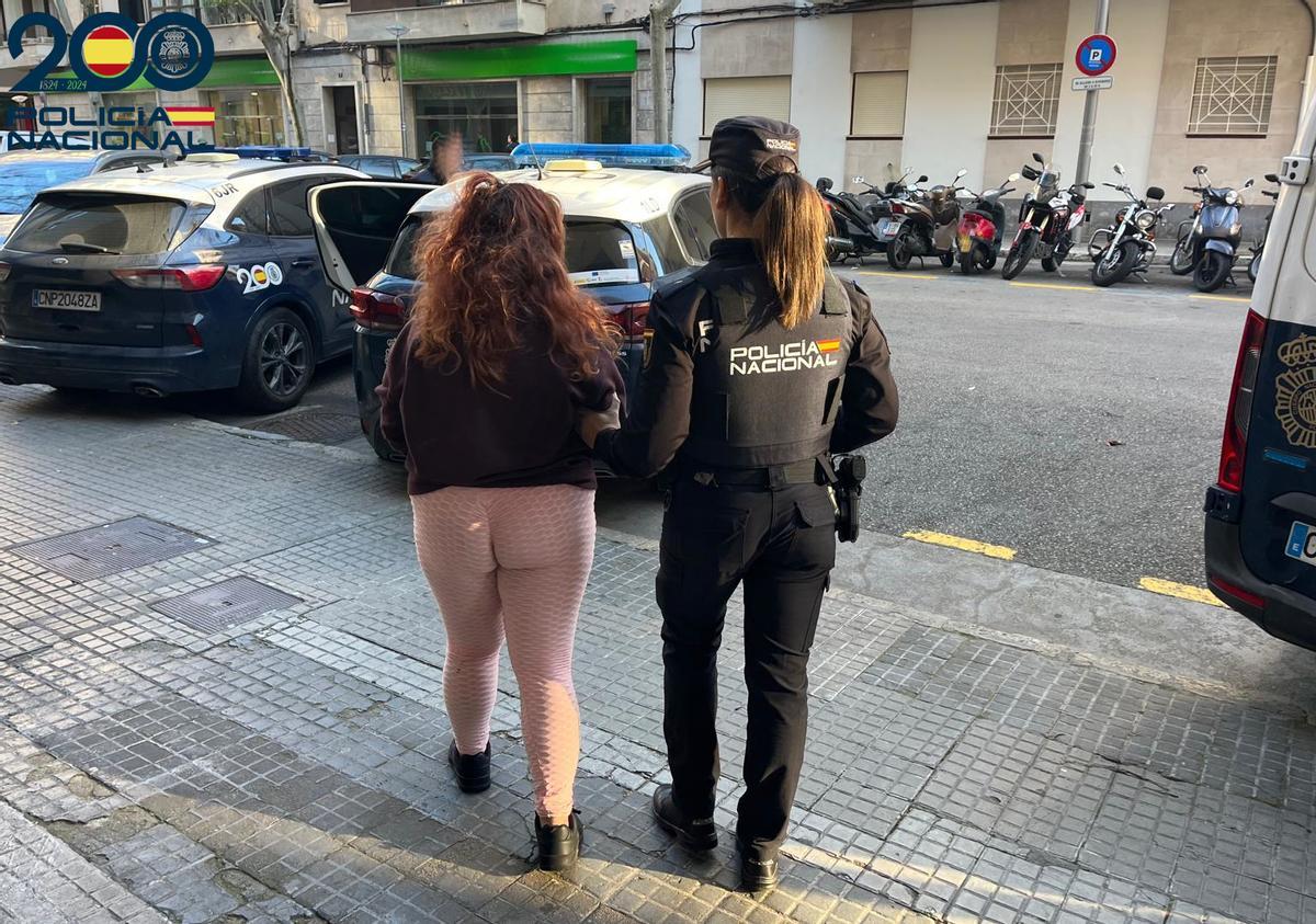 Una policía custodia a la mujer detenida por los diversos robos.