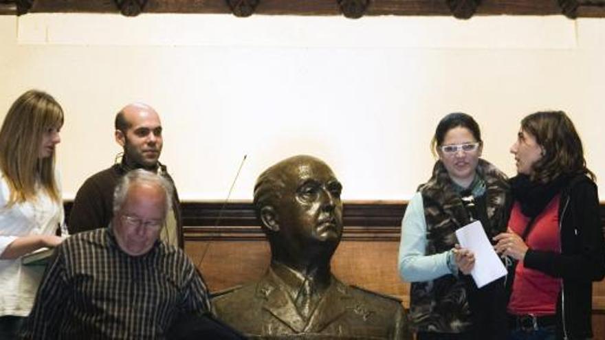 Viistantes en el pazo de Meirás, propiedad de la familia Franco, ante un busto del dictador.