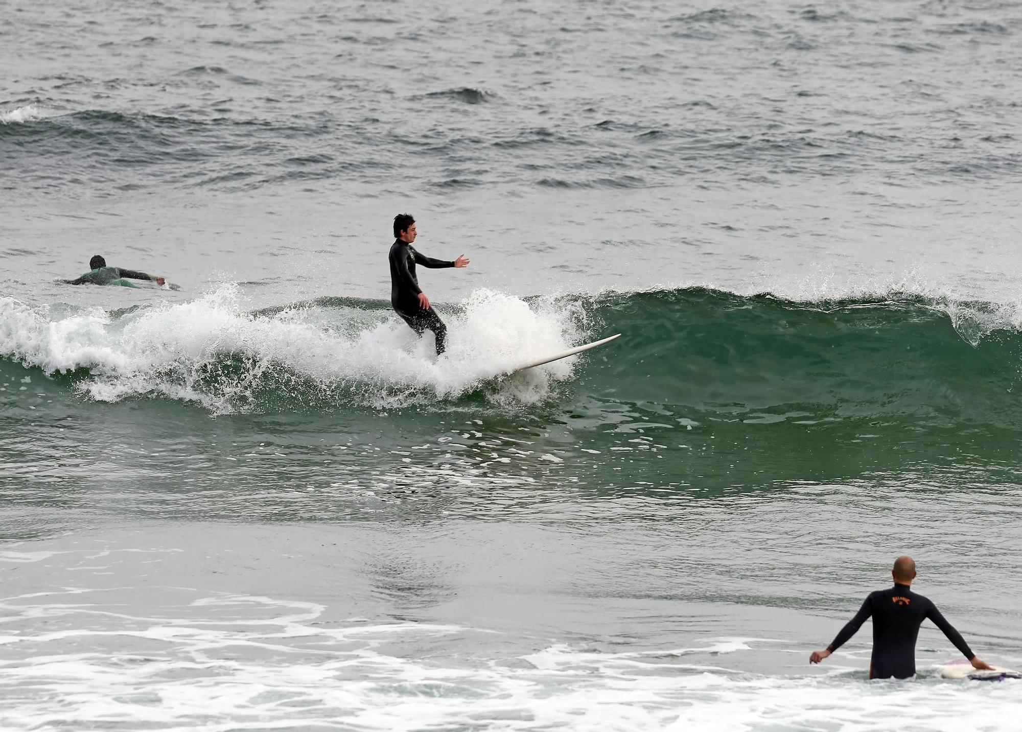 Surfistas practicando junto a la desembocadura del río Lagares y la playa de Samil