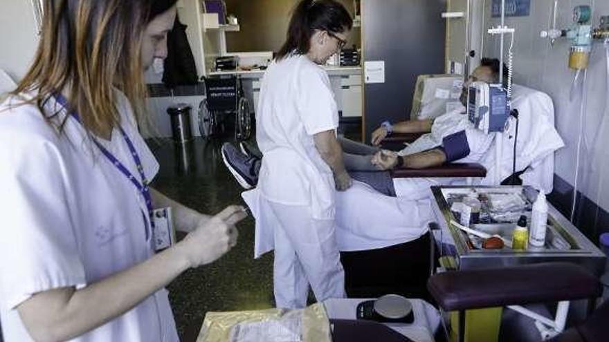 La enfermera Lorena Veiga, en primer término, preparando una extracción de sangre.