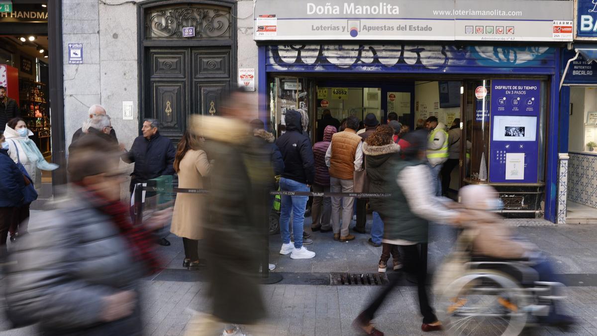 Imagen de archivo (28/11/2022) de varias personas haciendo cola para comprar décimos de Lotería para el sorteo navideño de El Gordo en la Puerta del Sol de Madrid.