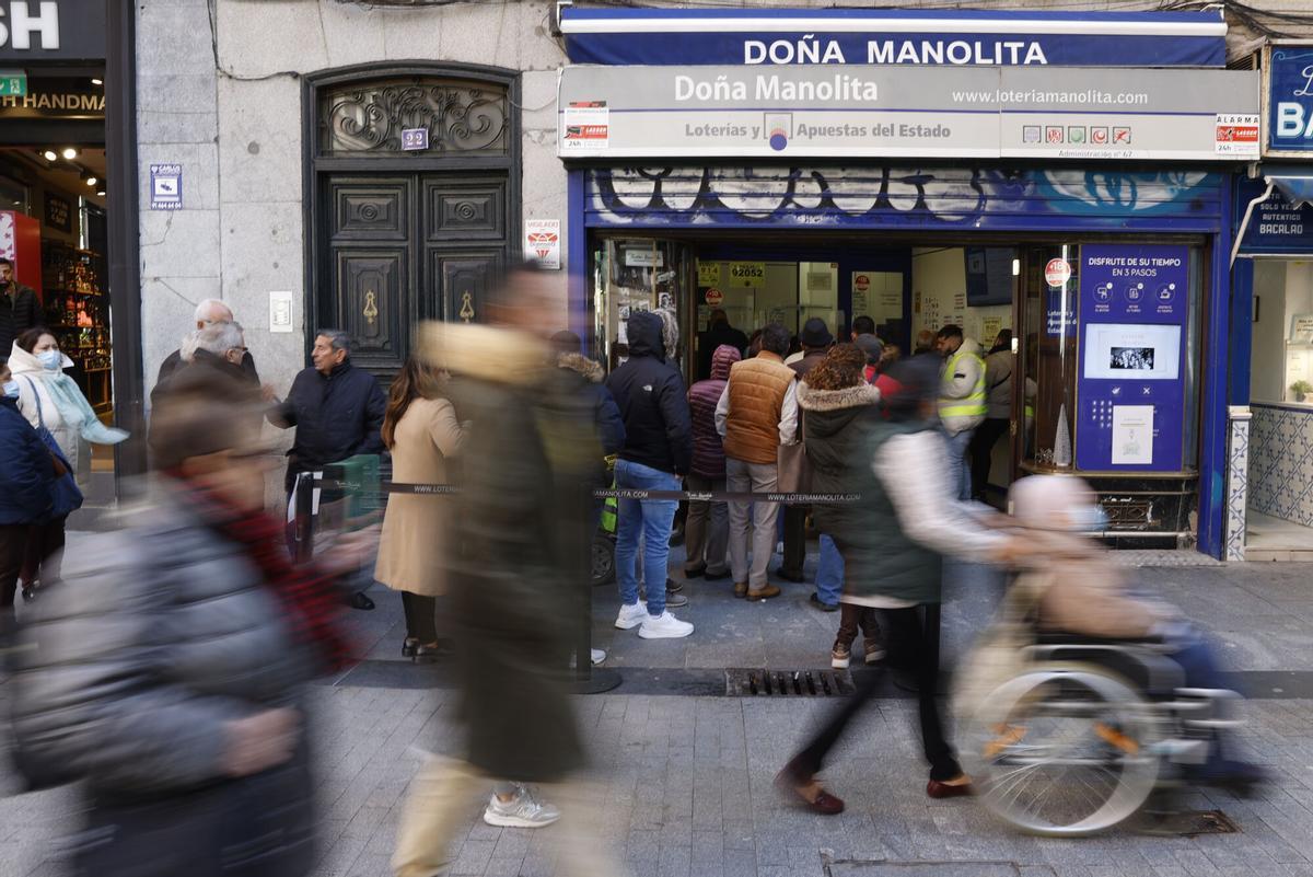 Imagen de archivo (28/11/2022) de varias personas haciendo cola para comprar décimos de Lotería para el sorteo navideño de El Gordo en la Puerta del Sol de Madrid.