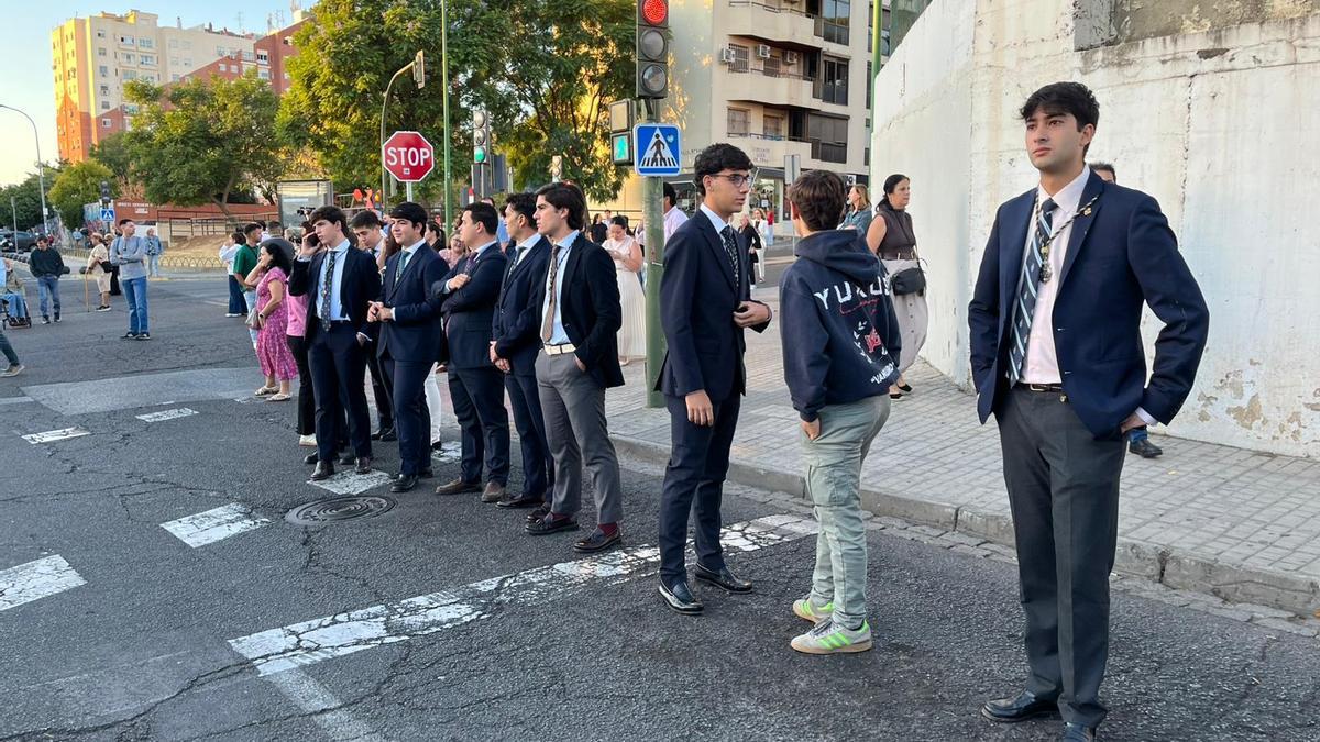 Componentes del grupo joven de la Esperanza preparados para el relevo en las andas.