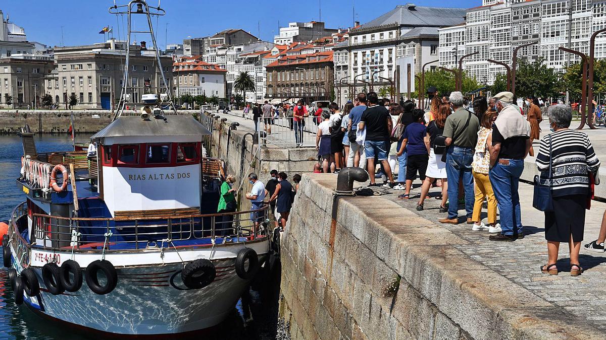 Pasajeros esperan para subir, este verano, a la lancha turística en la Marina.   | // VÍCTOR ECHAVE