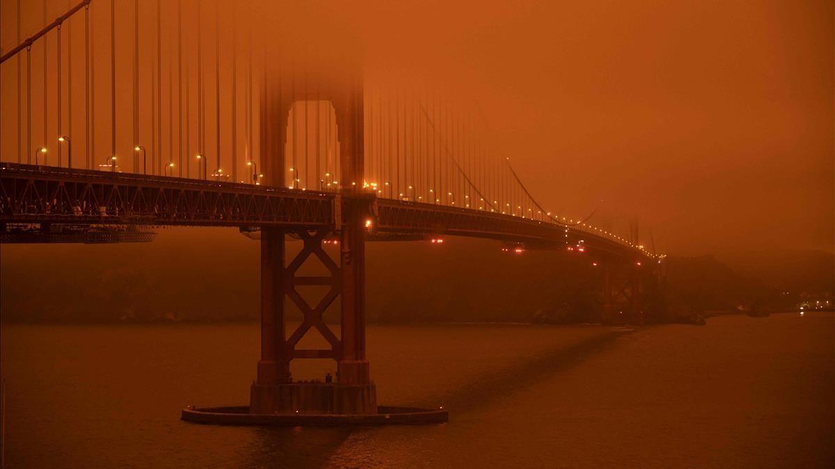 Los automóviles circulan por el puente Golden Gate bajo un cielo lleno de humo naranja al mediodía en San Francisco, California, el 9 de septiembre de 2020. 35 incendios forestales importantes, con al menos cinco ciudades sustancialmente destruidas  y evacuaciones masivas