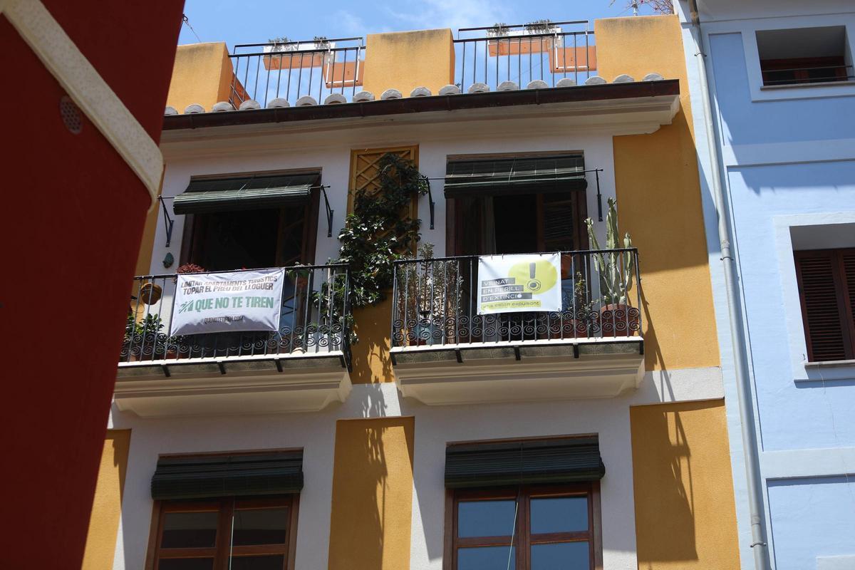 Carteles contra los pisos turísticos colgados en un balcón de Ciutat Vella.