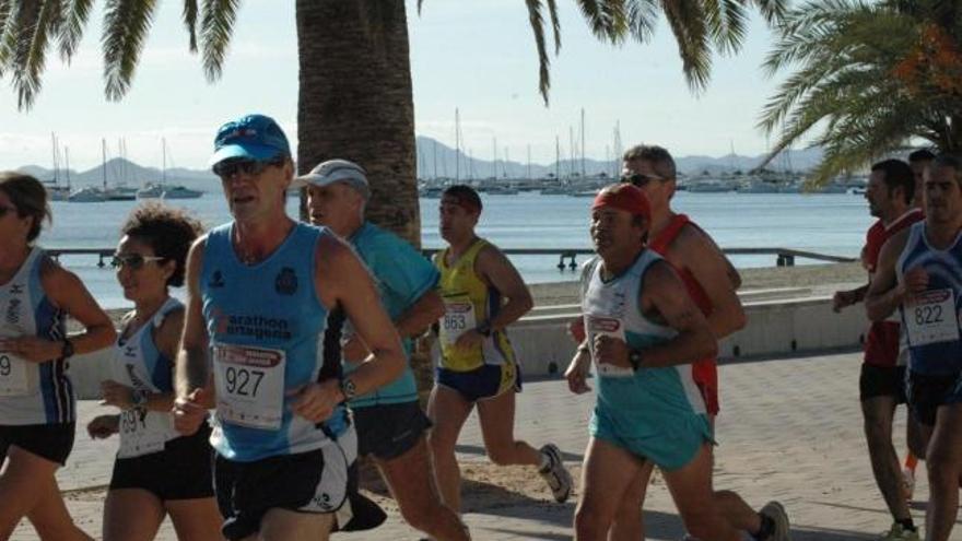 Un grupo de participantes en la carrera pasan junto a la playa de Barnuevo