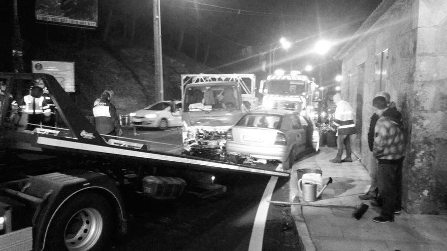 Una grúa recoge uno de los coches accidentados tras embestir al camión de butano.