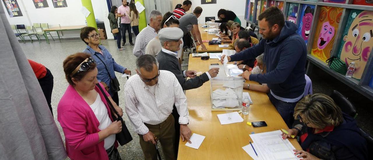 Electores ejerciendo el voto en las pasadas elecciones municipales en un colegio gallego.