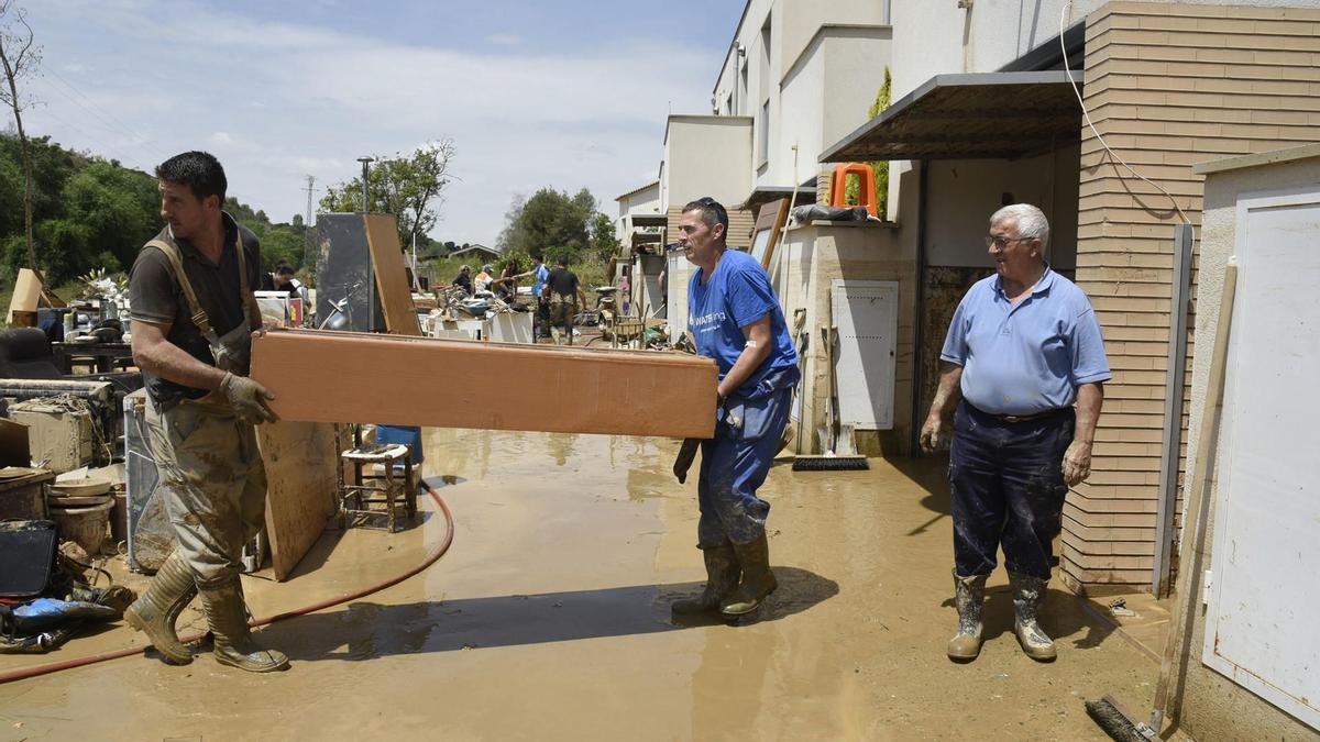 Los vecinos de Pomar de Cinca retiran los muebles dañados por la tromba de agua que inundó sus casas.