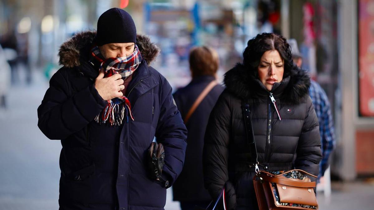 Dos personas caminando por el centro de Córdoba en una jornada fría.