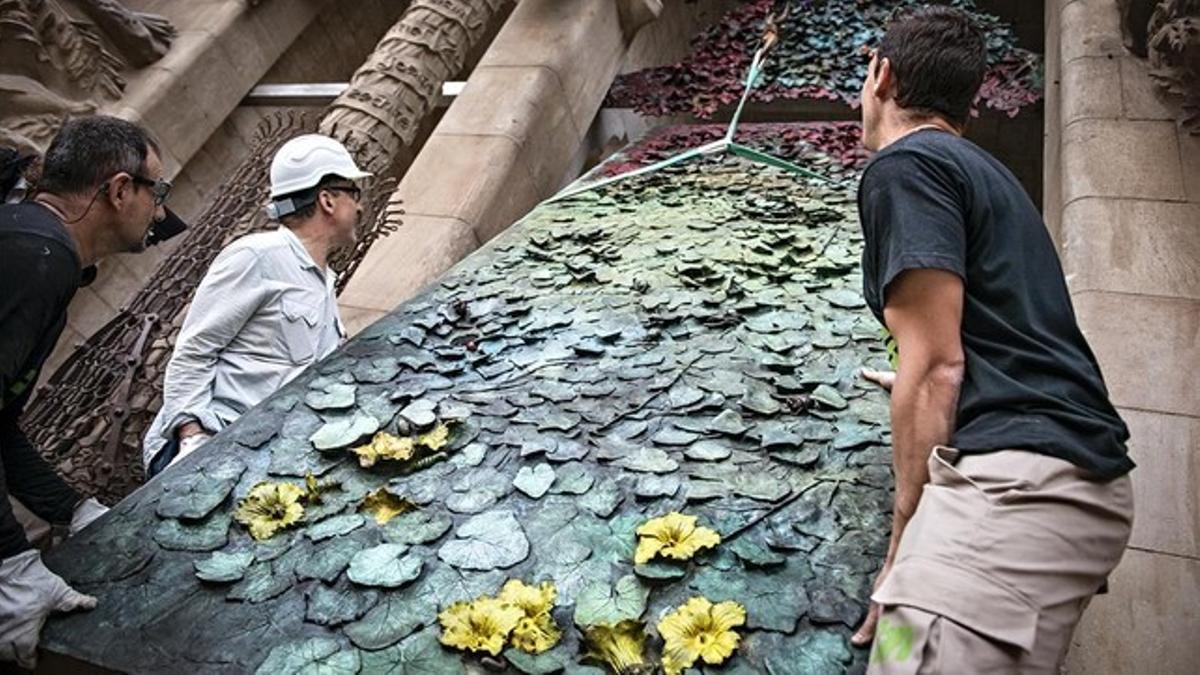 Trabajos de colocación de la primera puerta de la fachada del Naixement de la Sagrada Família.