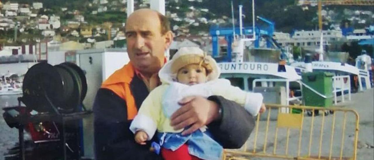 Paco Gil, con una de sus nietas, en el antiguo surtidor del puerto.