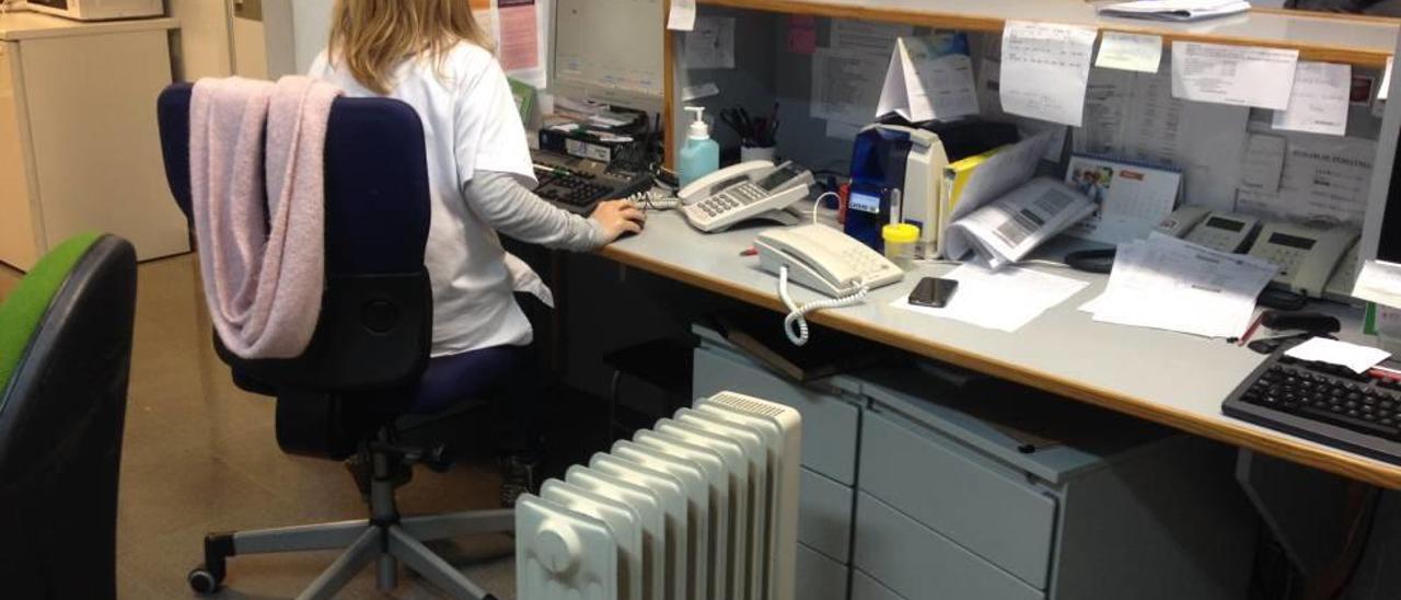 Una empleada atiende su puesto de trabajo junto a un calefactor particular.