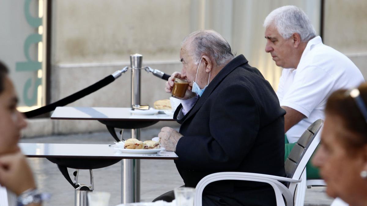 Varios clientes en una terraza en el centro.