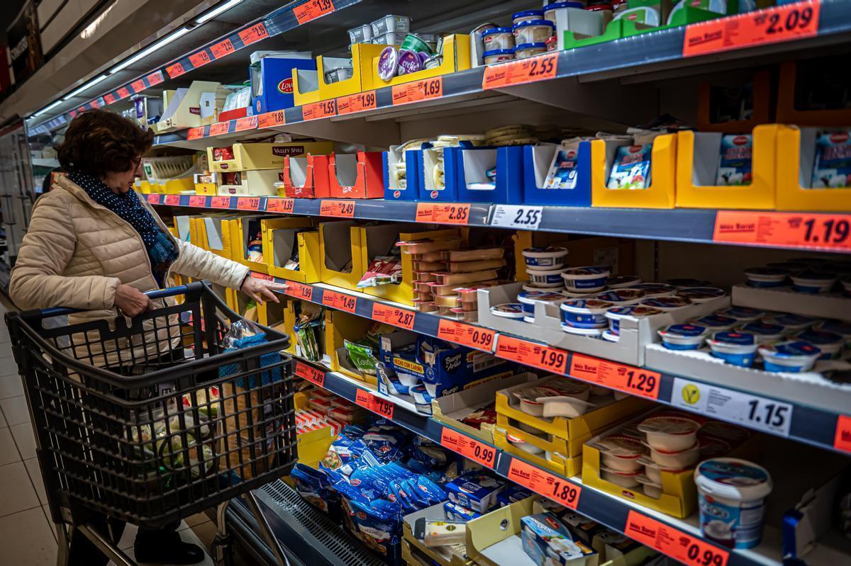 Una mujer compra en un supermercado en el primer día de la rebaja del IVA alimentario.