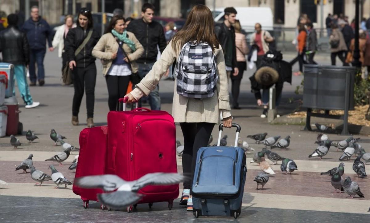 Una turista traslada maletas por el centro de Barcelona.