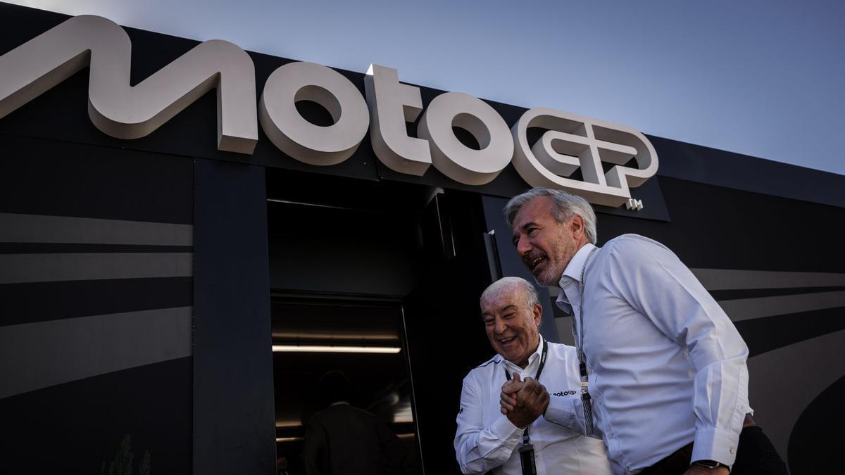 Jorge Azcón choca su mano con Carmelo Ezpeleta a la salida de su reunión en Motorland Aragón, este domingo.