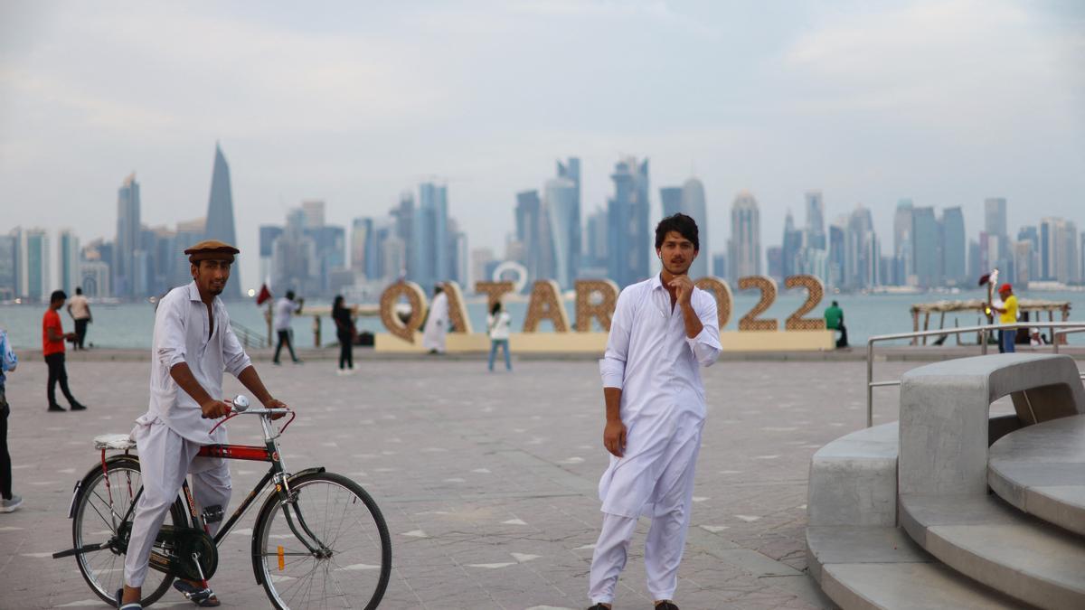 Un grupo de aficionados qataríes delante de uno de los letreros del Mundial.