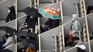 Espectadores en Roland Garros observando un partido de tenis femenino.