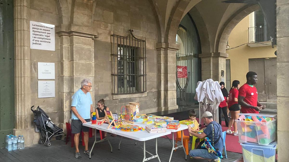 Posant els jocs aixopluc als porxos de la plaça Major