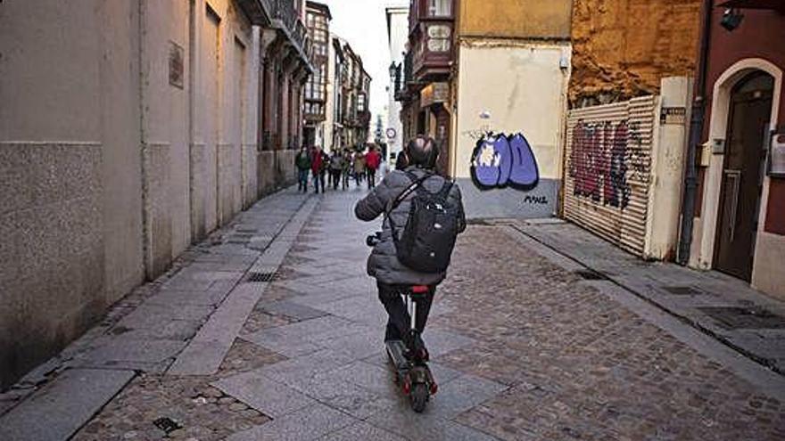 Un hombre en patinete eléctrico por el caso antiguo de Zamora.