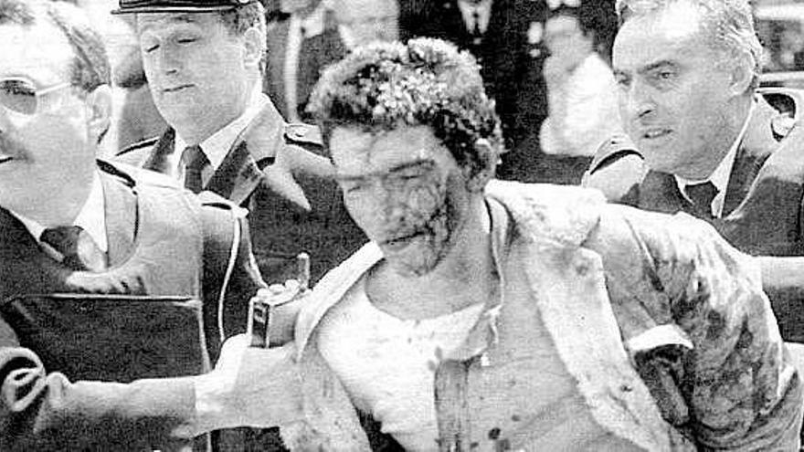 Santiago Cobos Fernández, ensangrentado, conducido por varios agentes policiales, tras su detención en 1995.