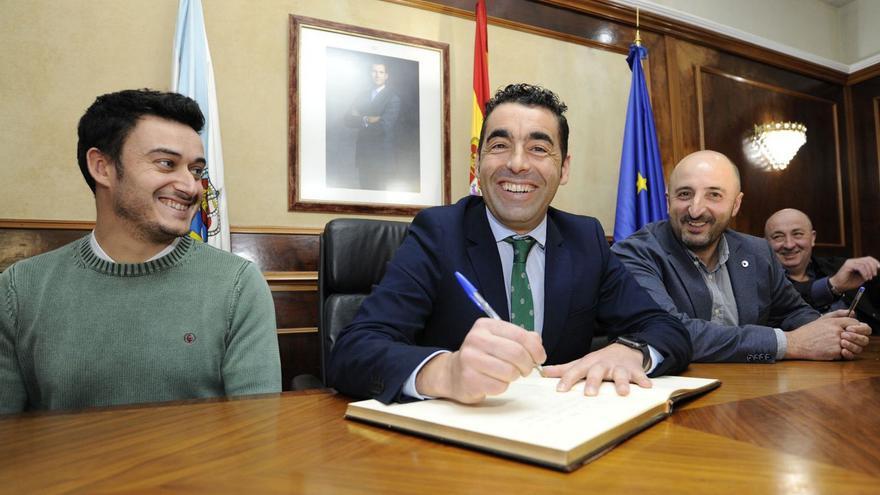 Luis López firma en el libro de honor flanqueado por miembros del gobierno local. |   // BERNABÉ/JAVIER LALÍN